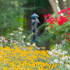 Bird feeder hanging among flowers and trees
