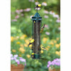 Bird feeder with birds perched on it against a blurred garden background
